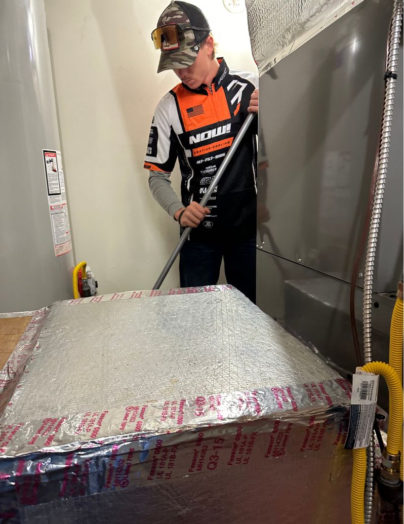 Now Heating & Cooling technician installing heating system